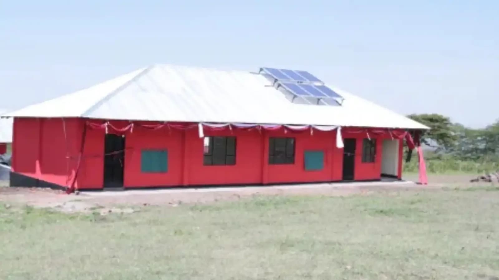 Roof-mounted solar panels on a rural school building, the array that powers its classrooms and evening study sessions.